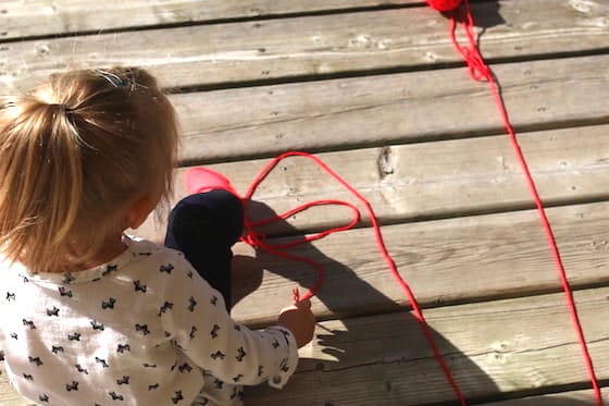 Toddler playing with yarn