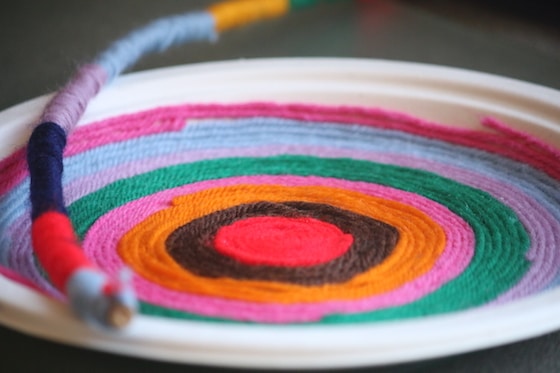 paper plate and twig wrapped with yarn