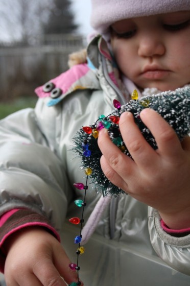 toddler examining christmas tree in sensory bin