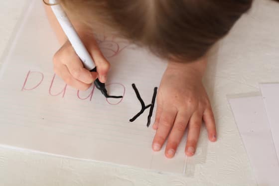 Child practicing writing her name