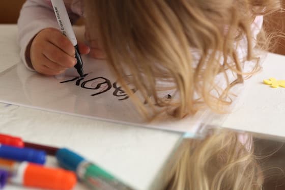 Child tracing the letters of her name