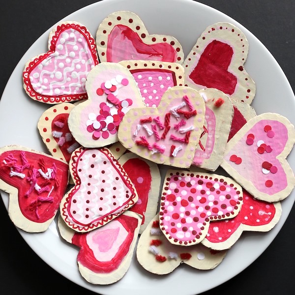 plate of cardboard heart cookies with paint icing and yarn sprinkles