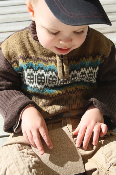 toddler examining sandpaper