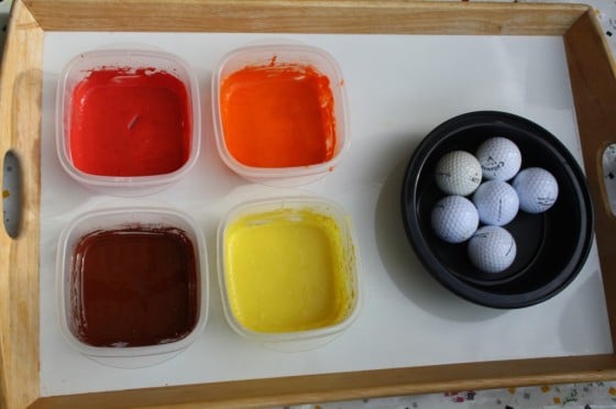 orange, yellow, brown and red paint on tray with golf balls