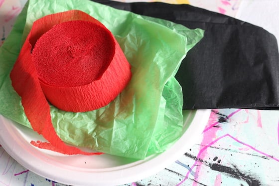 red crepe paper, green tissue paper, black tissue paper, paper plate