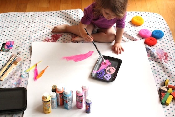 painting activities for toddler set out on a big cardboard canvas