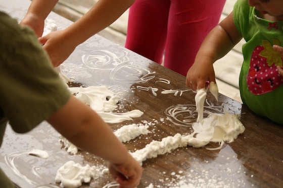 preschoolers exploring shaving cream on a table top