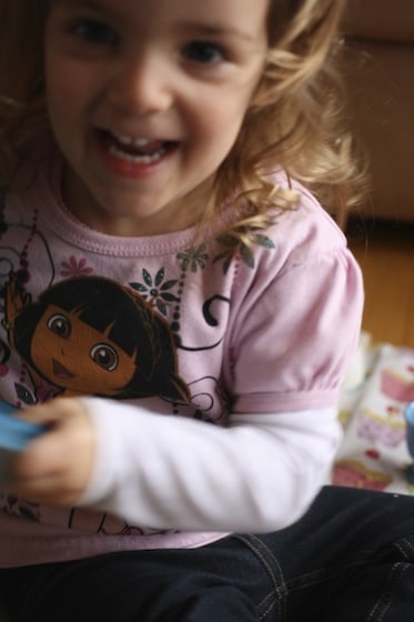 preschooler shaking a container of dry pasta and food colouring