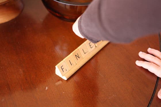 3 year old spelling her name with scrabble tiles