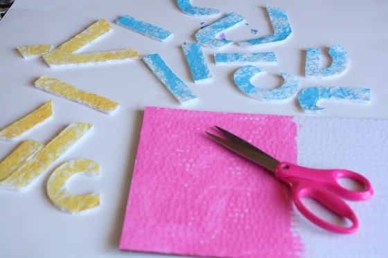 painted letters cut out of corrugated cardboard