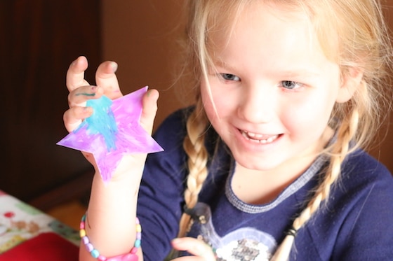 child holding up star coloured with sharpies