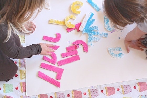 toddlers doing homemade name puzzle