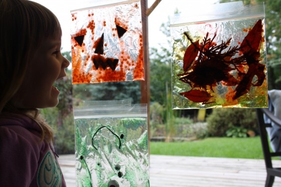 toddler laughing looking at hair gel sun catchers on sliding glass door