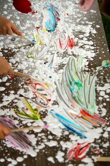 shaving cream, food colouring and craft sticks on a table top