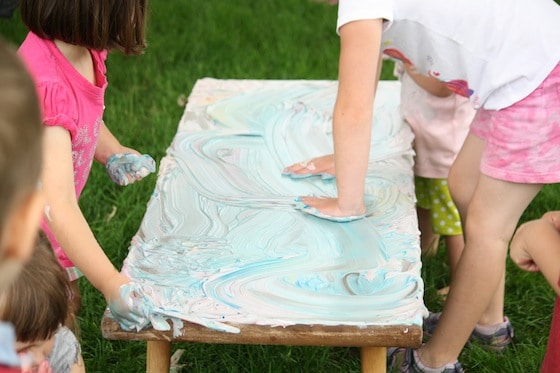 4 kids with hands in shaving cream on table