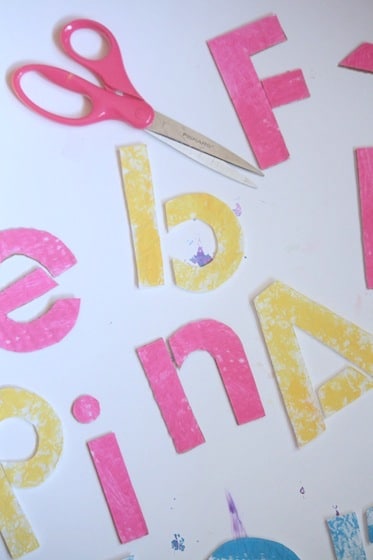 scissors and letters cut out for name puzzle