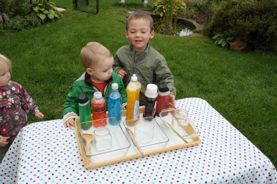 toddlers and preschoolers with tray of coloured water in squirt containers