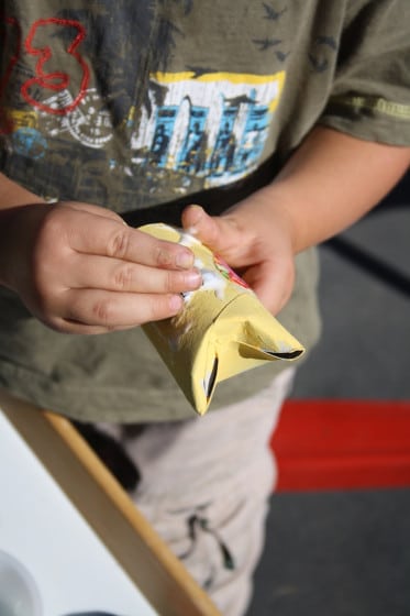 Preschooler gluing eyes on toilet roll owl