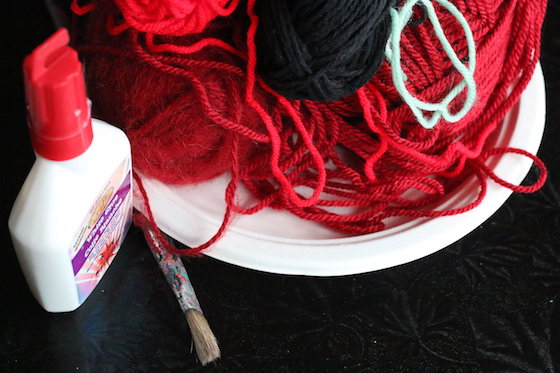 paper plate, red and black yarn, glue and paintbrush