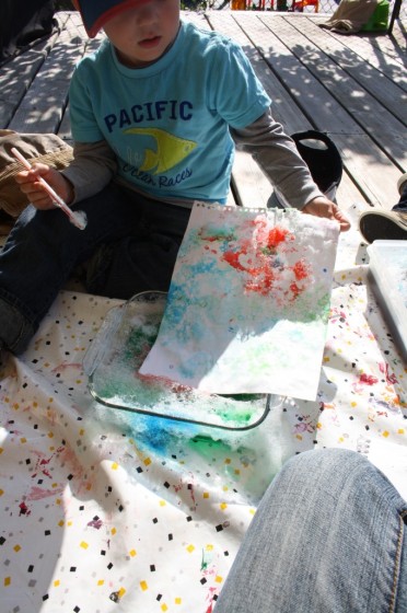 preschool boy pressing paper into bubble painting