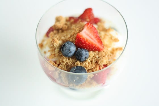 small glass dish with yogurt, fruit and crushed oatmeal cookies