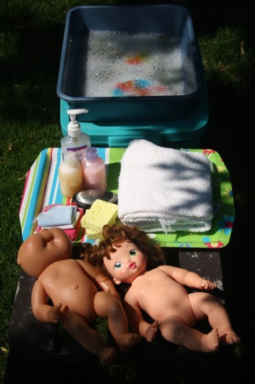 Dolls, soap, shampoo and basin of water for doll bath pretend play