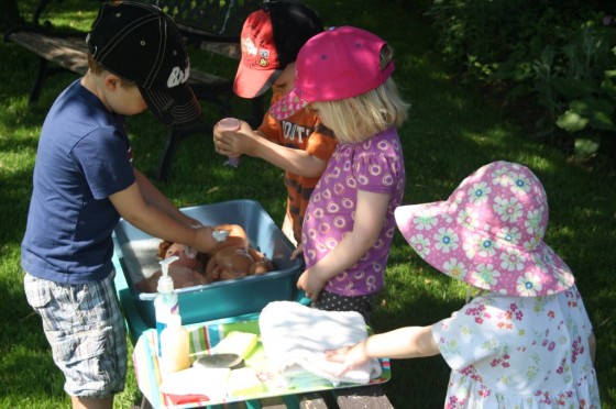 4 toddlers washing dolls