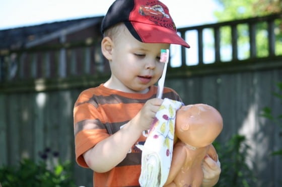 toddler drying doll with towel