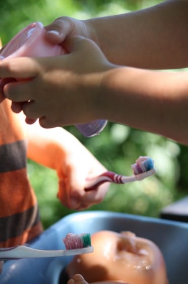 preschooler squeezing shampoo on doll