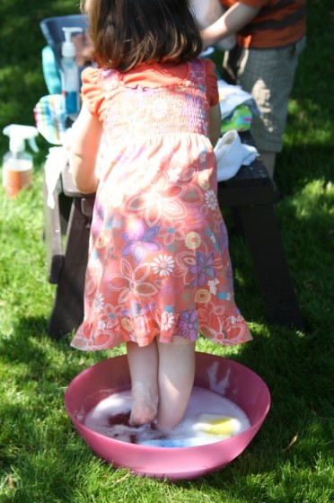 toddler standing in bowl of soapy water