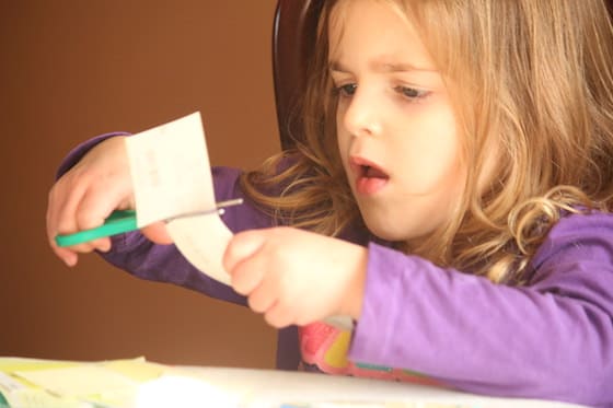 child cutting paint chip sample