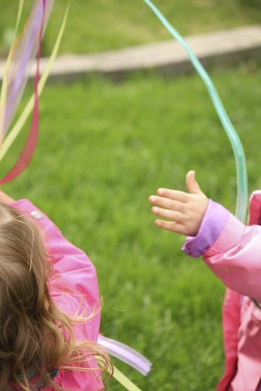 toddlers playing with windsock ribbons