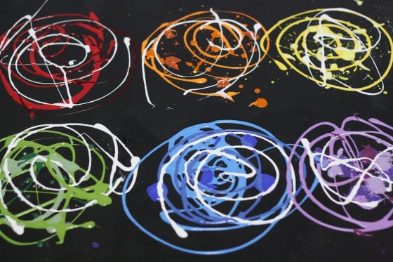 paint colours swirled on black canvas