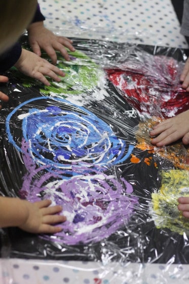 Painting covered in plastic wrap for kids to smoosh