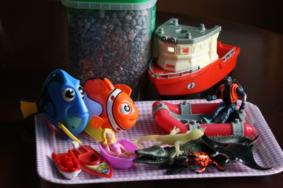 ocean toys and small stones on plastic tray