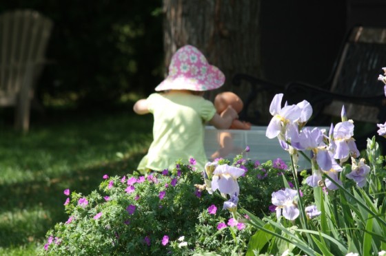 toddler in yard at water sensory bin 