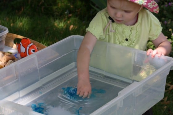 toddler playing in ocean sensory bin