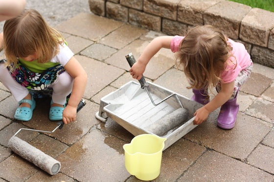 kids rolling paint rollers in water