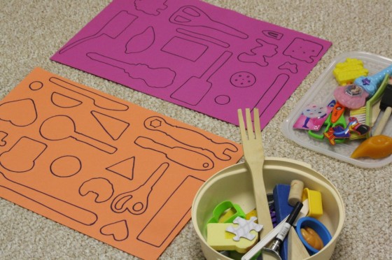 outlines of kitchen tools and toys on construction paper