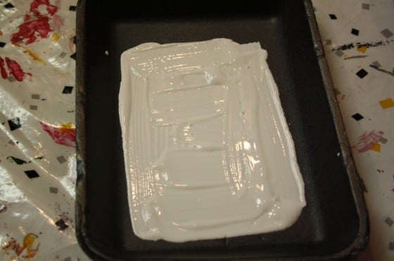 white paint in styrofoam produce tray for making prints with toddlers