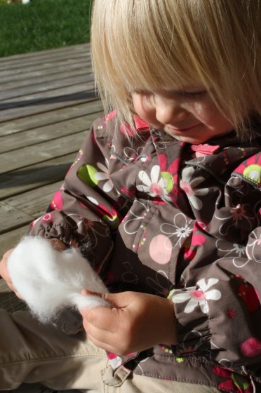 toddler pulling apart cotton ball 