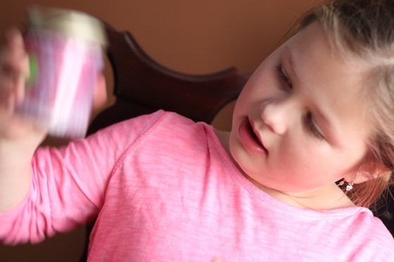 Child shaking jar of glitter