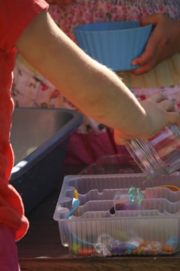 preschoolers playing with i spy sensory bin