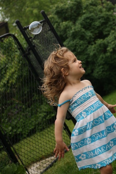 child chasing bubbles