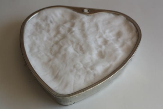 heart shaped feeder filled with corn, chestnuts and snow