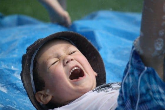 boy slipping and sliding on homemade water slide