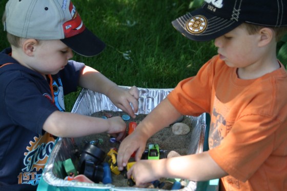 Kids playing with construction vehicles and construction worker figures