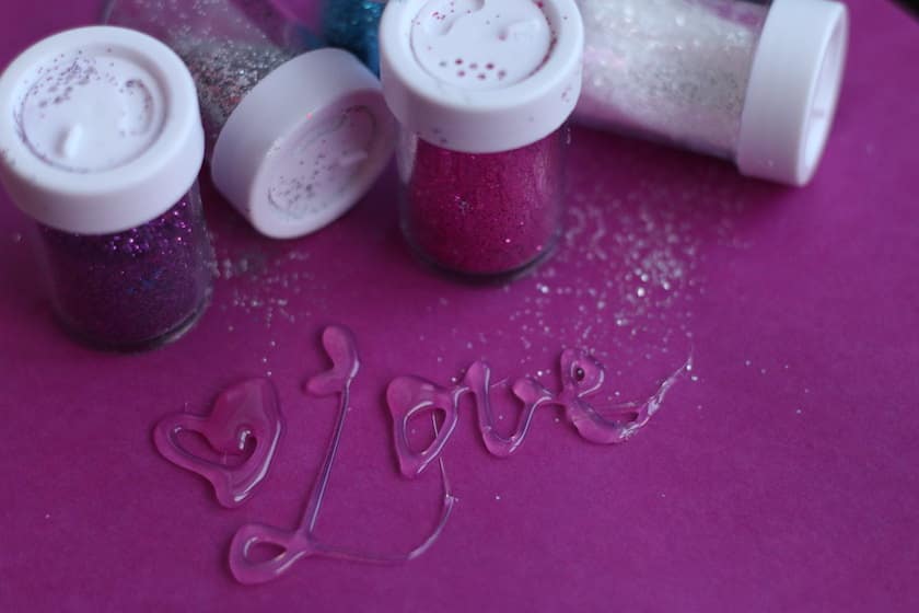 Love written in hot glue and glitter