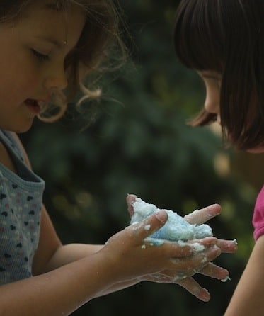 girls playing with blue clean mud