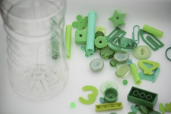 Clear bottle and green odds and ends on a styrofoam tray